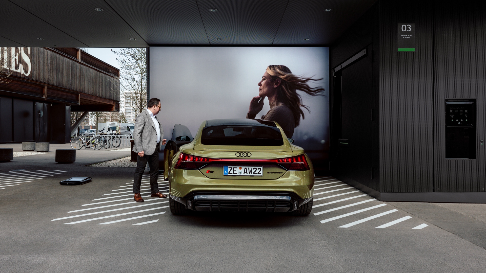 Helmuth Brants se tient à côté de l'Audi RS e-tron GT devant un grand écran.